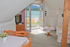a living room with a bed and a balcony at Seevilla Wochinz in Faak am See