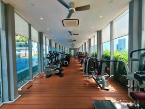 una sala de fitness con una fila de pisadas y máquinas en Vortex Suites Klcc By SALEH, en Kuala Lumpur
