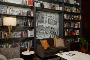 a living room with a couch and bookshelves at Manto Hotel Lima - MGallery in Lima