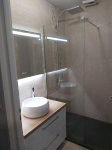 bagno con lavandino e doccia in vetro di VILLA Face à la Mer Sur le Sable 6 CLIM A L'ETAGE a Le Barcarès