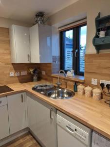 a kitchen with a sink and a counter top at The Coo Shed in Inverness