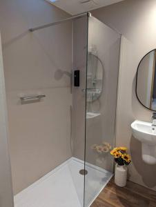 een glazen douche in een badkamer met een wastafel bij The Coo Shed in Inverness