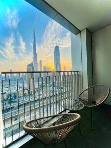 a balcony with two chairs and a view of a city at Downtown, Burj Khalifa Views, Dubai Mall Connected in Dubai