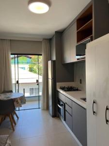 a kitchen with a refrigerator and a table in it at Caminho do Mar Ap 4 in Governador Celso Ramos