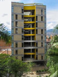 un edificio de apartamentos alto con balcones amarillos en Hotel Cytrico, en Medellín