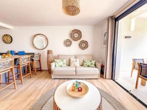 a living room with a couch and a table at Ultramarine direct access to Orient Bay beach 2 bedrooms in Orient Bay