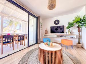 a living room with a table and a dining room at Ultramarine direct access to Orient Bay beach 2 bedrooms in Orient Bay