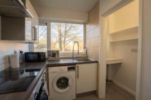 a kitchen with a washing machine and a sink at Stylish 2 bedroom apartment in Birmingham in Birmingham