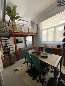 sala de estar con mesa de madera y sillas verdes en Estudio céntrico junto Wanda, Ifema y aeropuerto, en Madrid