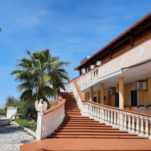 a staircase leading to a building with a palm tree at Residence Parco del Sole in Rodi Garganico