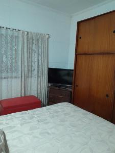 sypialnia z łóżkiem, komodą i telewizorem w obiekcie Malvinas casa w mieście La Plata