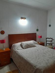sypialnia z łóżkiem, dwoma stołami i dwoma lampami w obiekcie Malvinas casa w mieście La Plata