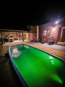 una piscina por la noche con iluminación verde en RANCHO GABRIEL en Mogi das Cruzes