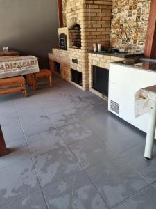cocina con suelo de baldosa y chimenea en RANCHO GABRIEL, en Mogi das Cruzes