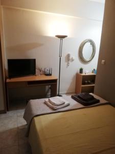 um quarto com uma cama e uma secretária com uma televisão em Apartment ARION 3 em Lárissa