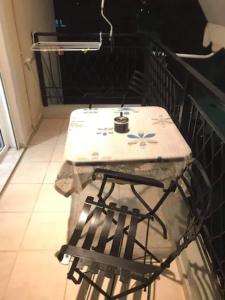 a table and chair sitting on top of a balcony at Apartment ARION 3 in Larisa