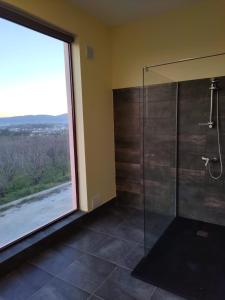 uma casa de banho com um chuveiro e uma janela grande em Tranca da Barriga - Casa do Vinho by Quinta De São Tiago em Covilhã