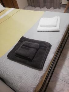 a bed with two towels sitting on top of it at Apartment ARION 3 in Larisa