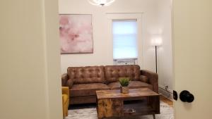 a living room with a brown couch and a table at Pinkston Gardens in Saint Paul