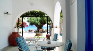 Cette chambre dispose d'une table et de chaises et offre une vue sur l'océan. dans l'établissement Lodge Narlis, à Platis Gialos