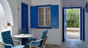 a table and chairs in a room with blue doors at Lodge Narlis in Platis Gialos