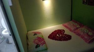 Una pequeña habitación con una cama con flores. en Shannkalay Hostel en Yangón