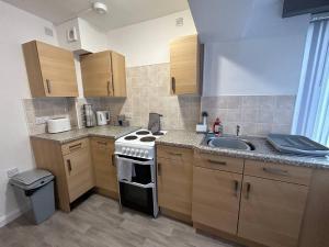 cocina con fregadero y fogones en Two bedroom apartment room 18 en Stockton-on-Tees