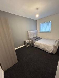 een slaapkamer met een bed en een raam bij Two bedroom apartment room 18 in Stockton-on-Tees