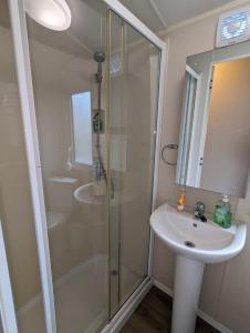 a bathroom with a shower and a sink at Seasons Caravan 3 bedroom Haven Littlesea in Weymouth