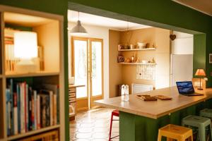 a kitchen with a table and a book shelf at La maison du Diplo : Forêt, sentiers et grimpe in Le Vaudoué