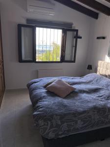 a bedroom with a blue bed with a window at Casa Moya Moraira - Seaview Villa in Teulada