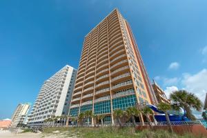 a tall building with palm trees in front of it at Phoenix Gulf Shores 1604 in Gulf Shores