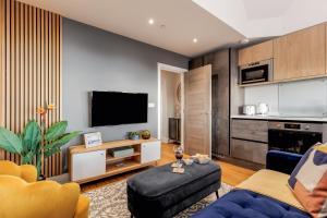 a living room with a couch and a tv at Tower House Apartments in Bournemouth