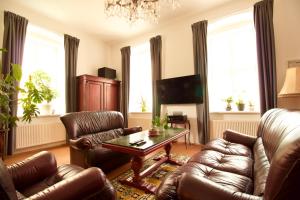 a living room with leather furniture and a chandelier at Villa Haag in Haag