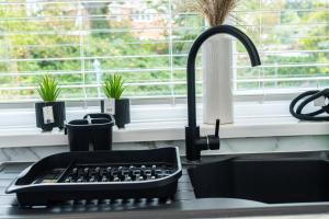 a kitchen counter with a sink and a kitchen sink at Modern 4-Bed Retreat with Garden in Manchester