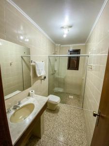 La salle de bains est pourvue d'un lavabo, de toilettes et d'une douche. dans l'établissement Hotel Radar, à Gravataí