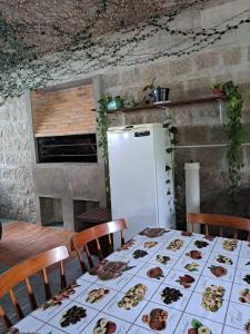 a kitchen with a table and a refrigerator at Velho Estaleiro Apartamentos por Temporada in São Lourenço do Sul