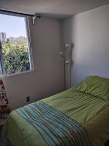 Schlafzimmer mit einem Bett und einem Fenster in der Unterkunft Casa 2 recámaras 3 personas in Mexiko-Stadt