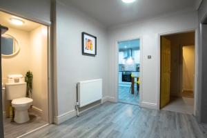 baño con aseo y pasillo en Brattan House Oxton Wirral 5 bedroom 3 bathroom with on-street parking ideal for vans by Rework Accommodation en Birkenhead