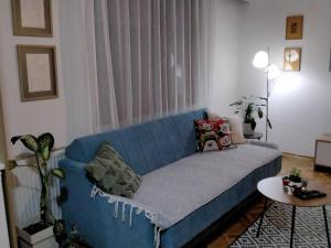 um sofá azul numa sala de estar com uma mesa em Fina Apartment em Leskovac