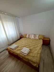 una camera da letto con un letto con due asciugamani sopra di Apartament 2 camere Brazda lui Novac a Craiova