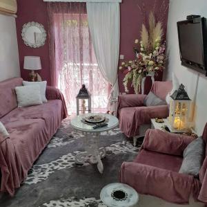 sala de estar con muebles de color rojo y mesa en DreamHouse, en Nafpaktos