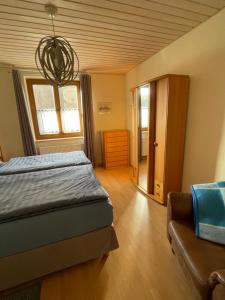 1 dormitorio con cama, sofá y lámpara de araña en Ferienwohnung Schneider, en Ottendorf-Okrilla
