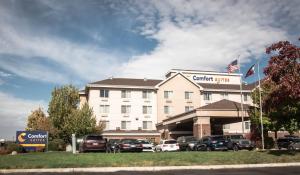 a hotel with cars parked in front of it at Comfort Suites Airport in Salt Lake City