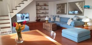 a living room with a blue couch and a vase with flowers at Acquamarina in Rapallo