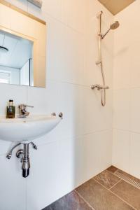 Baño blanco con lavabo y espejo en Appartement / Bed en Breakfast Kaatsheuvel, en Kaatsheuvel