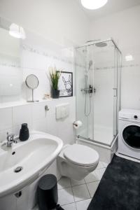 ein weißes Bad mit einem WC und einer Dusche in der Unterkunft Ferienwohnung Lorenz mit kostenlosem Parkplatz Netflix Boxspringbett Küche in Magdeburg
