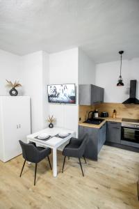 - une cuisine avec une table et des chaises blanches dans la chambre dans l'établissement Ferienwohnung Lorenz mit kostenlosem Parkplatz Netflix Boxspringbett Küche, à Magdebourg