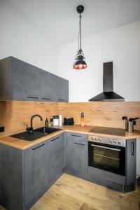 a kitchen with a sink and a stove at Ferienwohnung Lorenz mit kostenlosem Parkplatz Netflix Boxspringbett Küche in Magdeburg