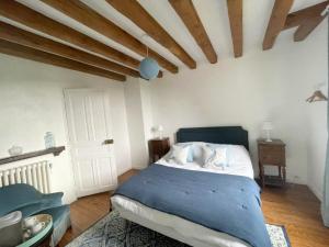 um quarto com uma cama com um cobertor azul em Le Manoir de Sainte-Aulde 